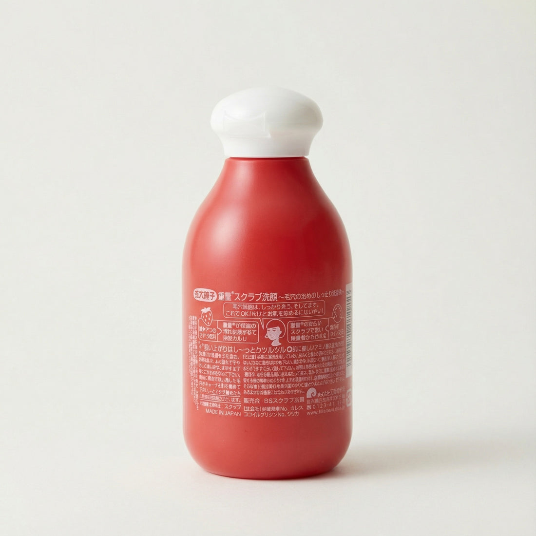 Red bottle of KEANA Baking Soda Scrub Wash with a white cap on a light beige background